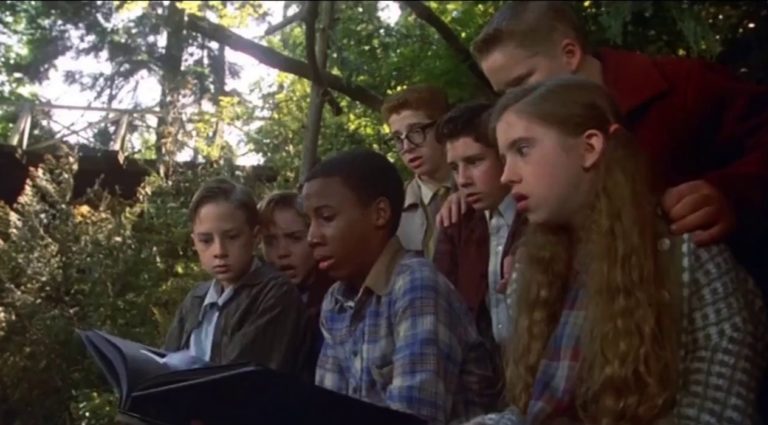 The kids of Stephen King's It (1990) look at a photo of Pennywise.