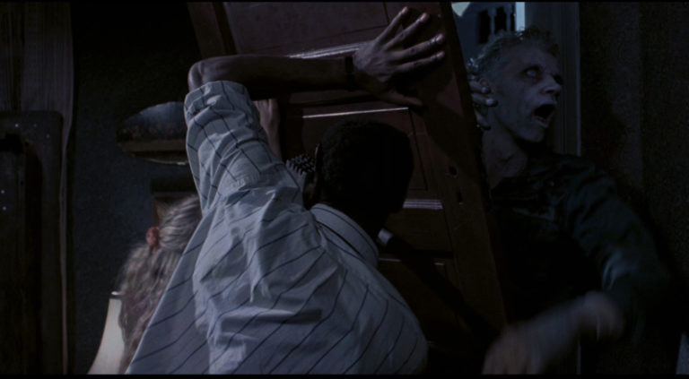Ben (Tony Todd) attemptes to keep the zombies out in Night of the Living Dead (1990).