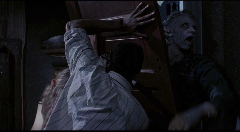 Ben (Tony Todd) attemptes to keep the zombies out in Night of the Living Dead (1990).
