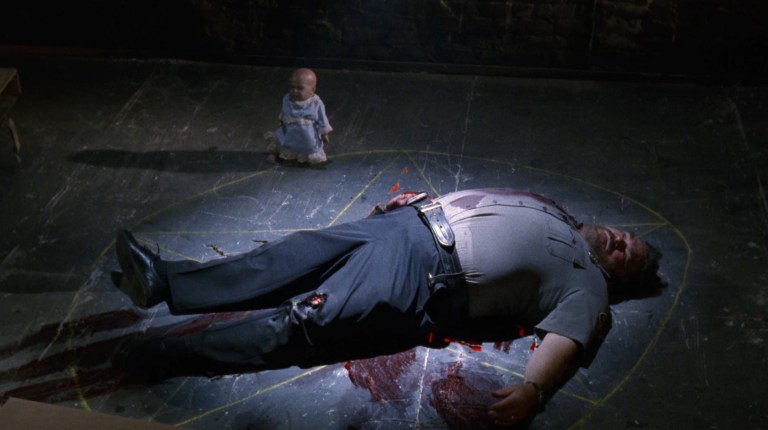 A killer baby doll with a dead guy in a pentagram in Demonic Toys (1992).