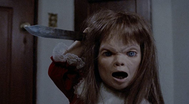 A killer doll with a knife in Dolly Dearest (1991).