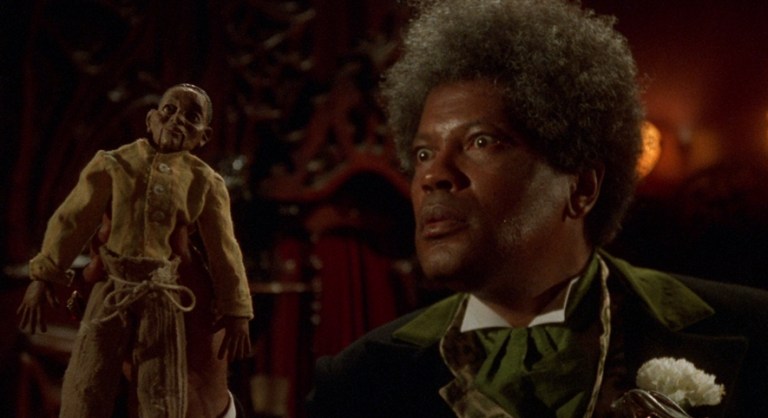 Mr. Simms (Clarence Williams III) holding a plantation doll in Tales from the Hood (1995).