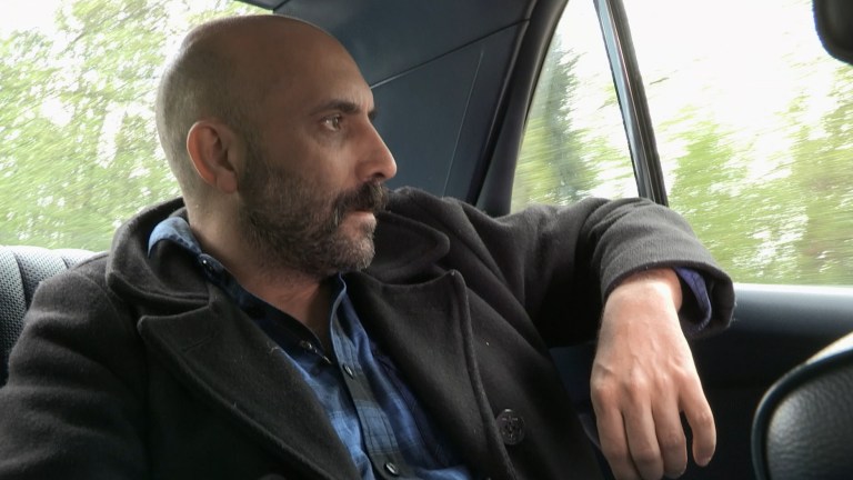 Gaspar Noe taking a ride in the back seat of a car.