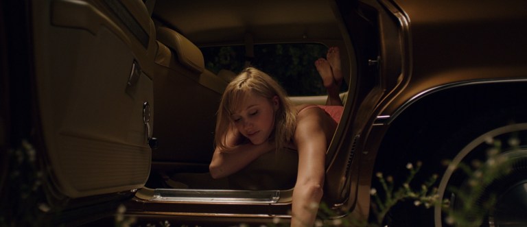 Maika Monroe in the backseat of a car in It Follows (2014).