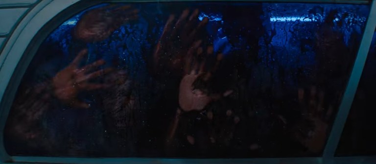 Bloody hands look for an exit from the party bus in Texas Chainsaw Massacre (2022).