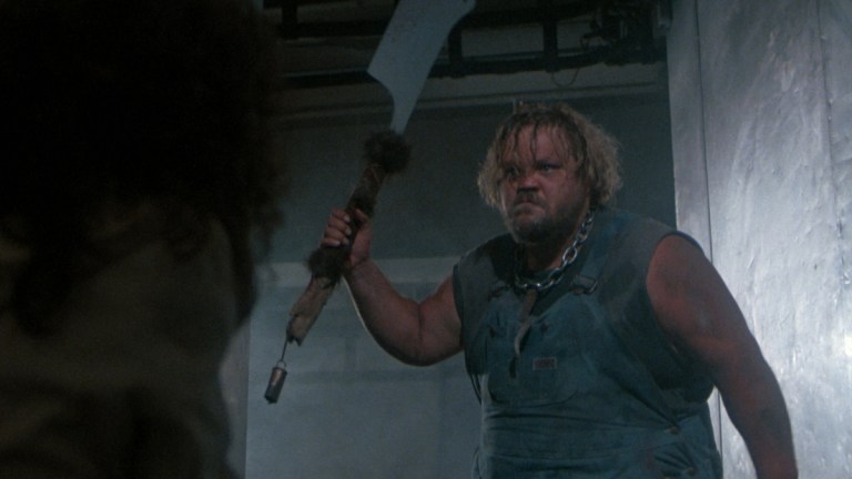 Buddy threatens someone with a giant knife in Slaughterhouse (1987)