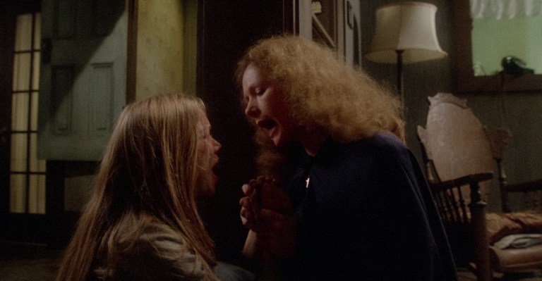 Carrie being forced by her mother to pray in Carrie (1976).