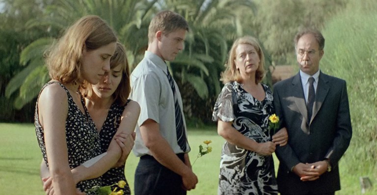 The family attends a fake memorial in Dogtooth (2009).