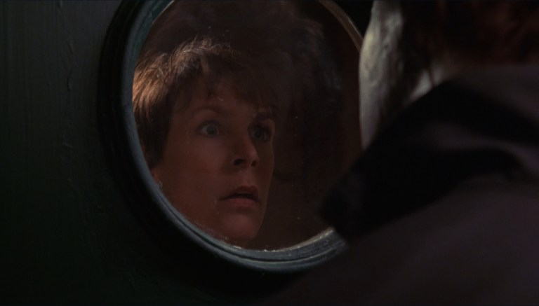 Laurie Strode peers at Michael Myers through a window in Halloween: H20 (1998).