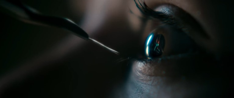 A needle is dangerously close to Bridget's eye in Evil Dead Rise (2023).