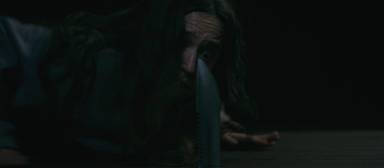 Parker is nearly stabbed in the face by a knife in Sick (2022).