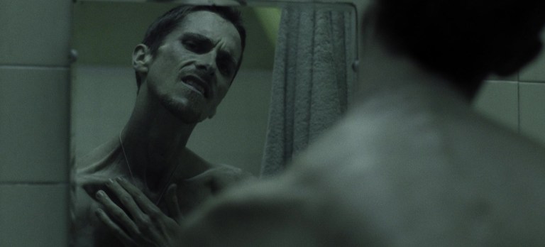 An alarmingly skinny Christian Bale looks at himself in a mirror in The Machinist (2004).