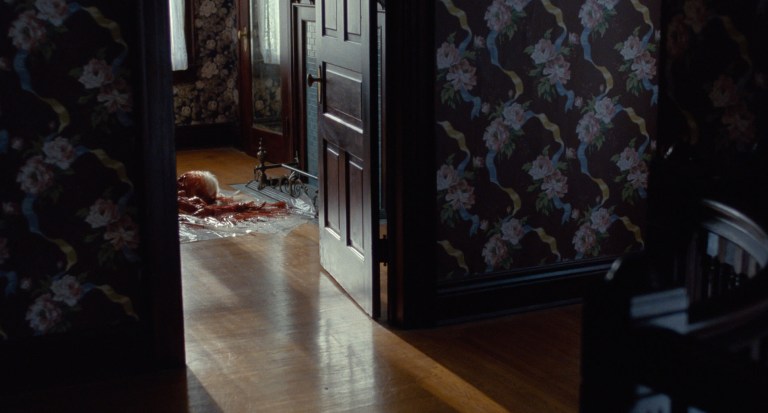 The bloody corpse of a woman is shown in another room in Bones and All (2022).