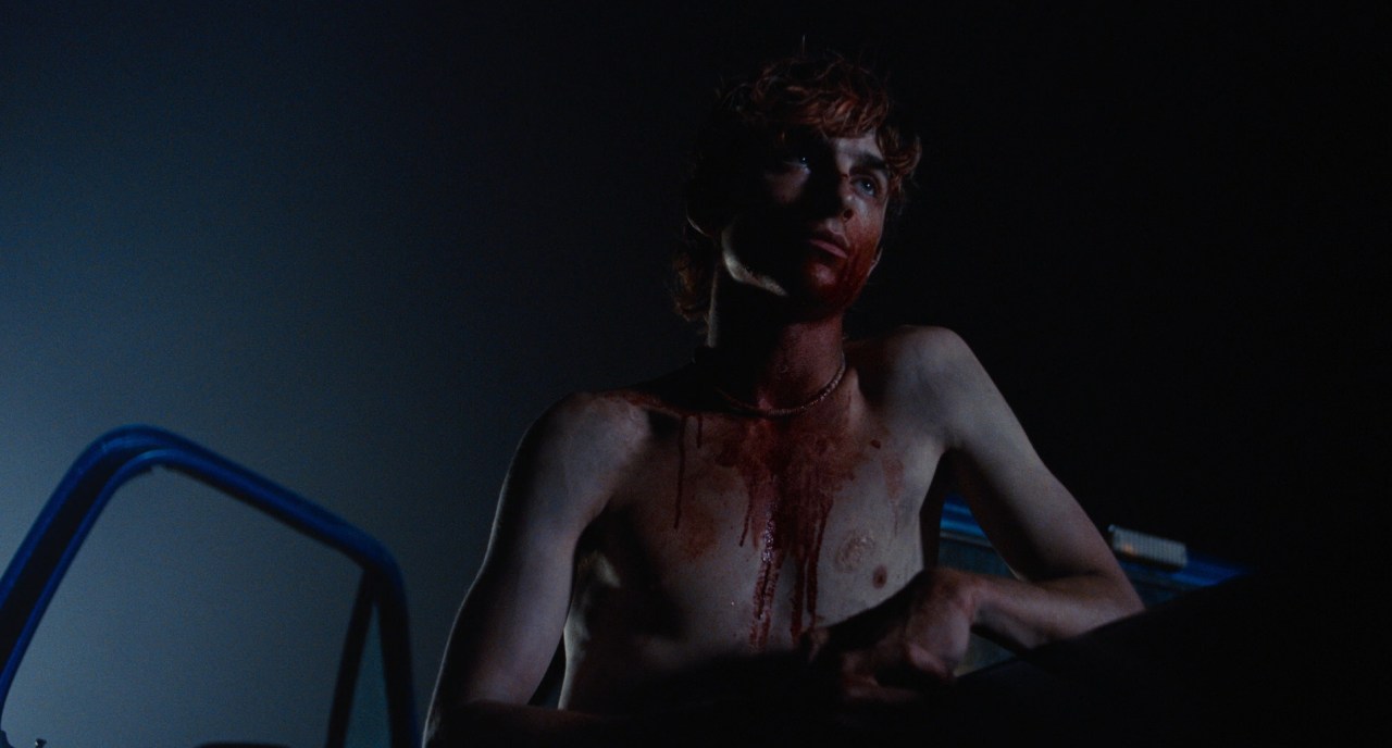 Lee stand by a truck covered in blood in Bones and All (2022).