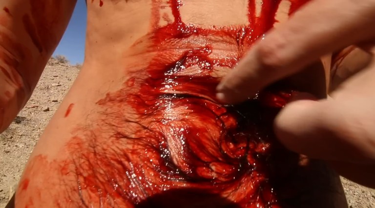 Someone's torso is covered in blood in The Outwaters (2023).
