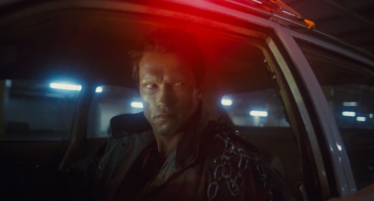 The T-800 searches for Sarah in a patrol car in The Terminator (1984).