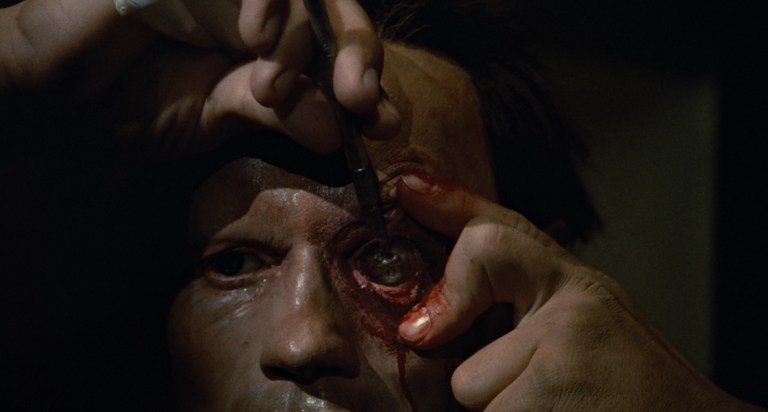 The T-800 takes a blade to its eye in The Terminator (1984).