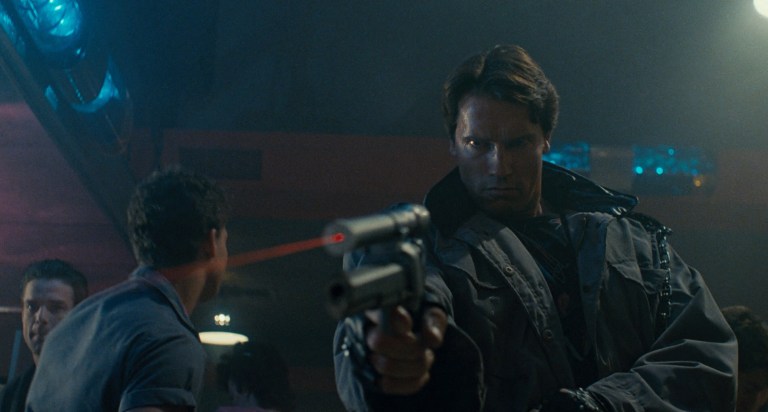 The T-800 points a gun in club Tech Noir in The Terminator (1984).