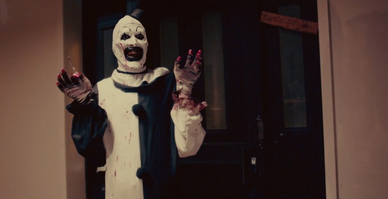 Art the Clown (David Howard Thornton) smiles while holding his hands up in Terrifier (2016).