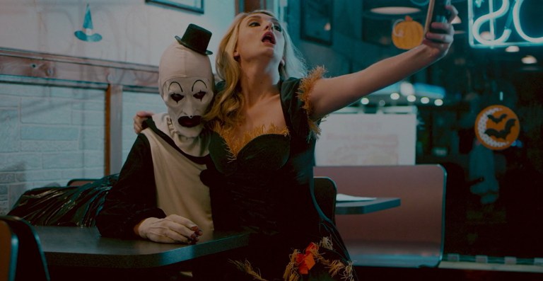 Dawn (Catherine Corcoran) takes a selfie with Art the Clown (David Howard Thornton) in Terrifier (2016).
