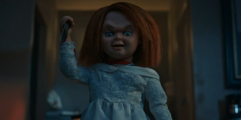 Chucky in a Belle dress, holding a knife.