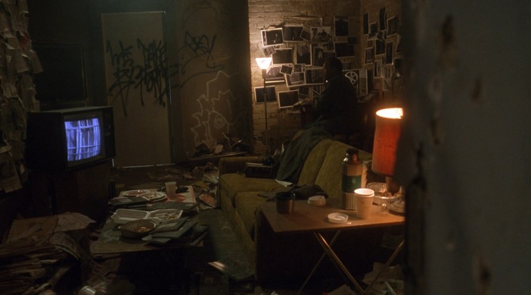 Detective Tapp sits in his gross apartment in Saw (2004).