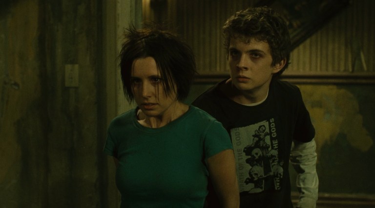 Amanda stands in front of Daniel in Saw II (2005).