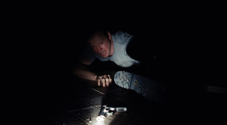 Eric Matthewstries to reach his gun in Saw III (2006).