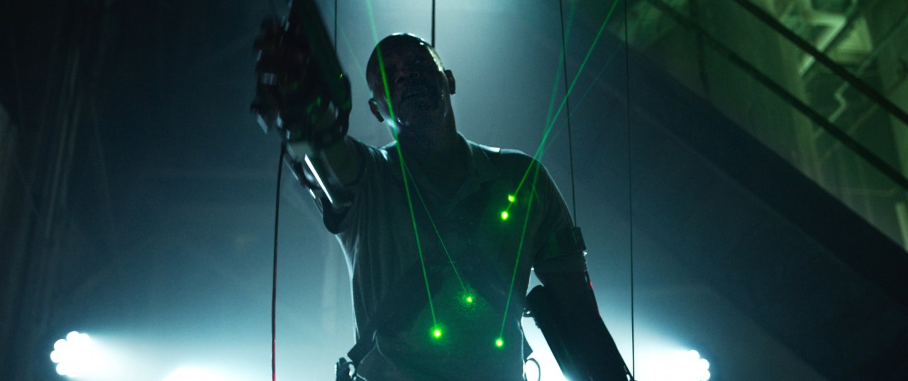 Marcus is forced to raise a gun towards police officers in Spiral (2021).