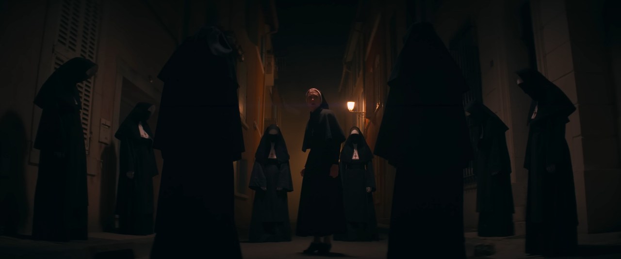 Irene is surrounded by multiple nuns in The Nun II (2023).