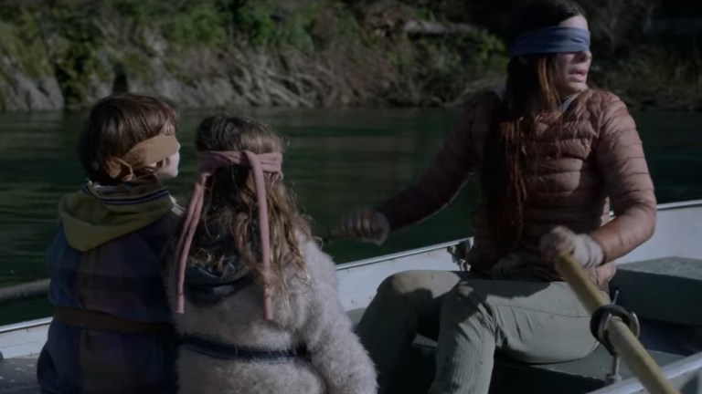 Sandra Bullock in Bird Box (2018) rowing a boat with two kids.
