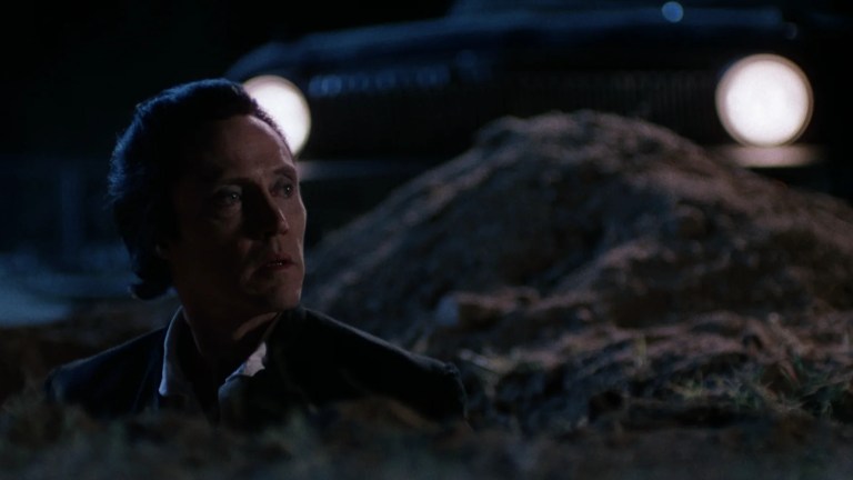 Christopher Walken looking out of a grave in the Prophecy film series.