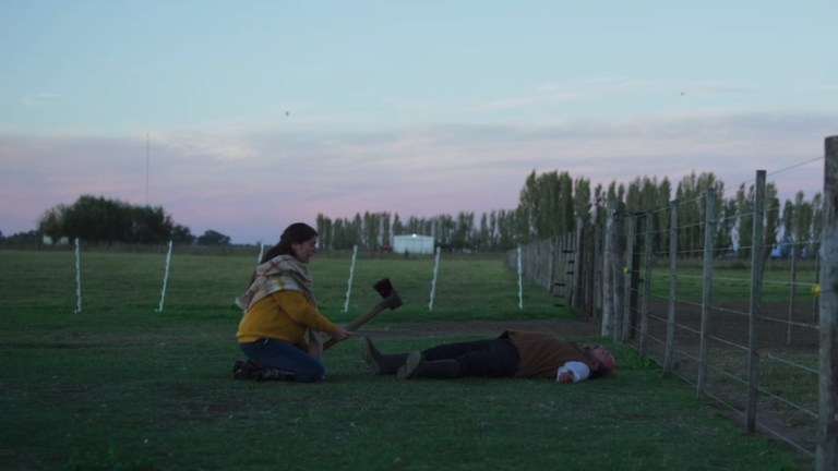 Jimena holds an axe towards her own face in WHen Evil Lurks (2023).