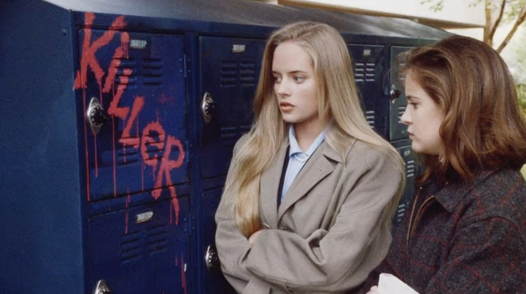 Two high-school students look at a locker with "Killer" written on it in Death of a Cheerleader (1994).