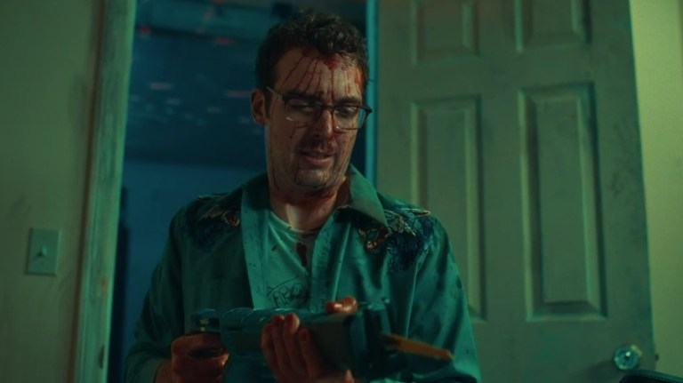 Jonah Ray holds a saw in Destroy All Neighbors (2024).
