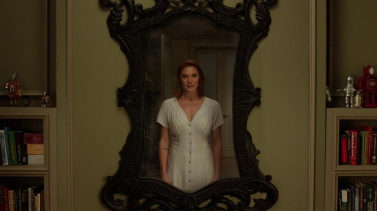 Katee Sackhoff, as Marie, is reflected in an antique mirror in Oculus (2013).