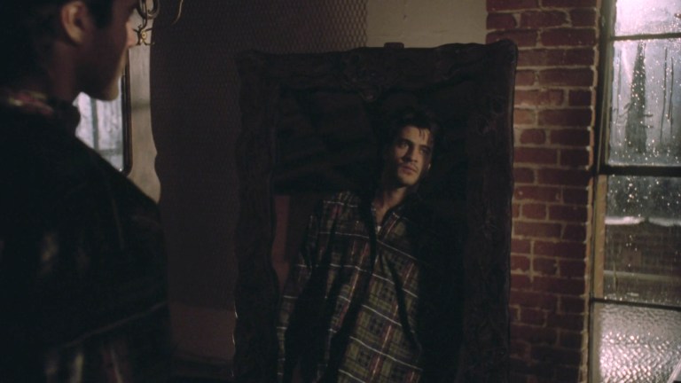 A man looks at his reflection in a cursed mirror in Amityville: A New Generation (1993).