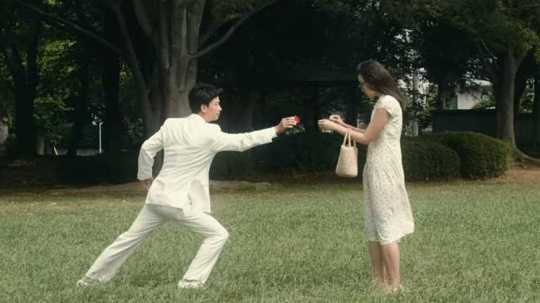 A man gives a woman a heart-shaped box in The Forest of Love (2019).