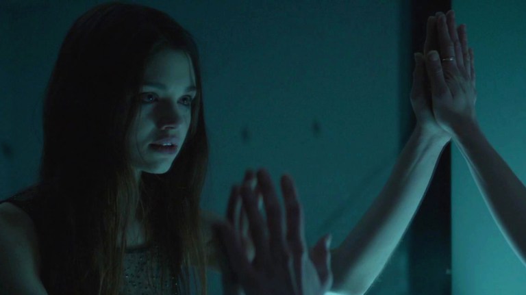 India Eisley looks into a mirror in Look Away (2018).
