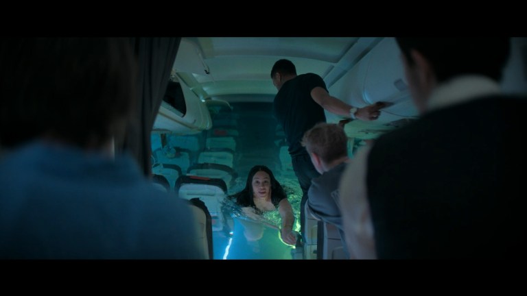 Ava swims down the aisle of a partially flooded airplane in No Way Up (2024).