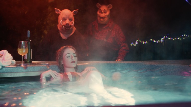 Piglet and Pooh approach a woman (Natasha Tosini) who is relaxing in a hot tub in Winnie-the-Pooh: Blood and Honey (2023).