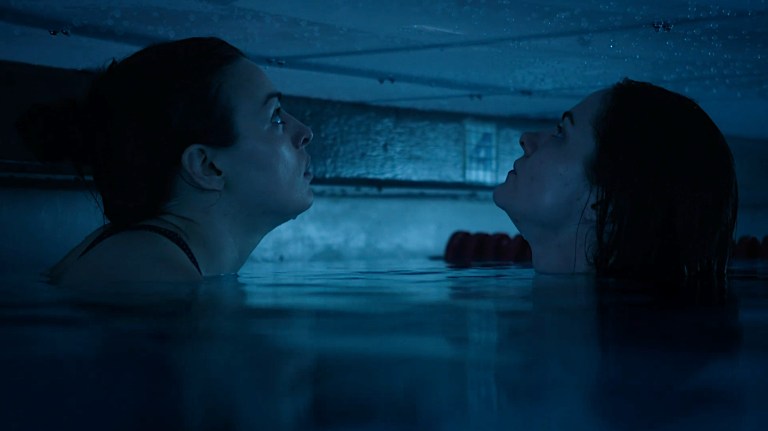 Two women look up at the pool cover that is trapping them in 12 Feet Down (2017).