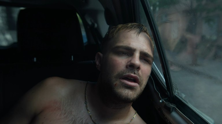 Ciro tiredly looks out of the window of the vehicle he is trapped inside in 4x4 (2019).