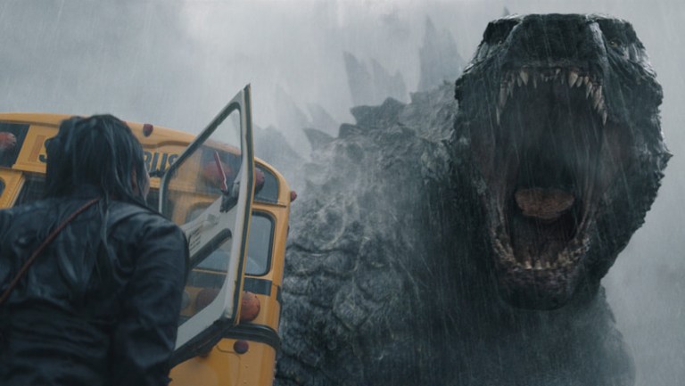 Godzilla roars at a persone beside a school bus in Monarch: Legacy of Monsters (2023).