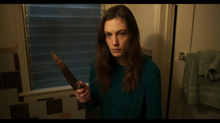 Phoebe Tonkin holds a knife as Gwen in Night Shift (2023).