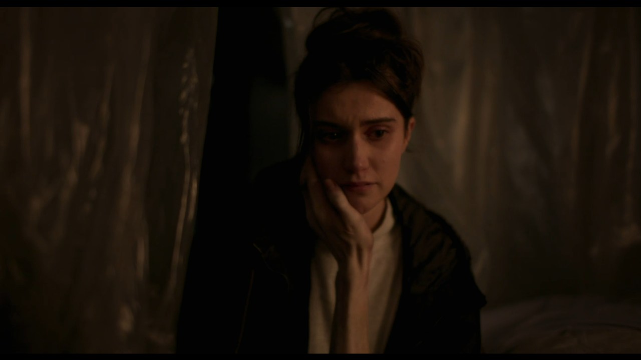 Anna has an emaciated hand caress her face in All You Need is Death (2023).