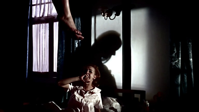 A girl in bed screams as she sees the figure of a person hanging from the ceiling in Even the Wind is Afraid (1968).