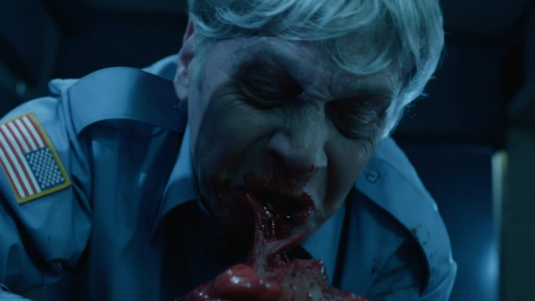 A zombie chews on bloody flesh in Festival of the Living Dead (2024).