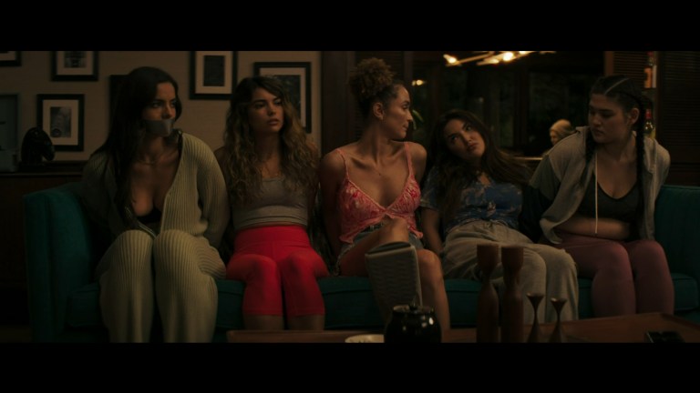 The models in Model House (2024) are tied up while sitting together on a couch.