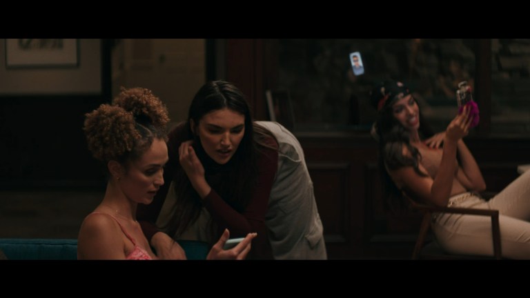 Trudy looks at Zoe's phone in Model House (2024).